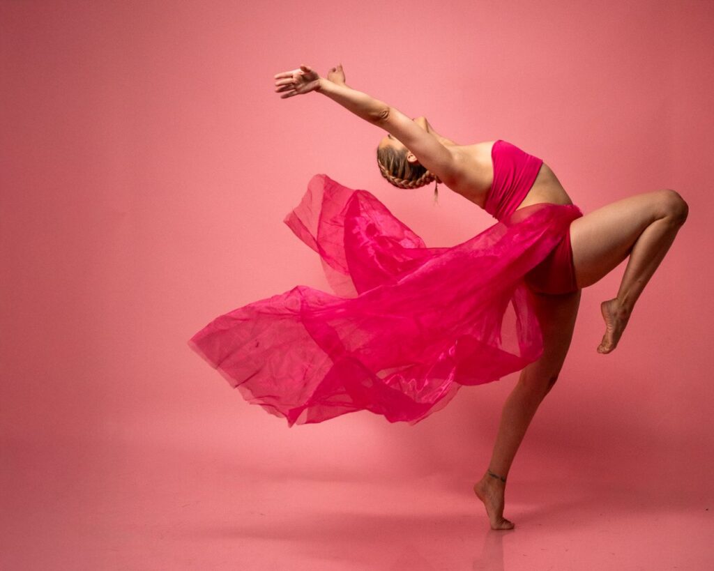Dynamic contemporary dancer in a pink outfit performing in Mexico City studio.